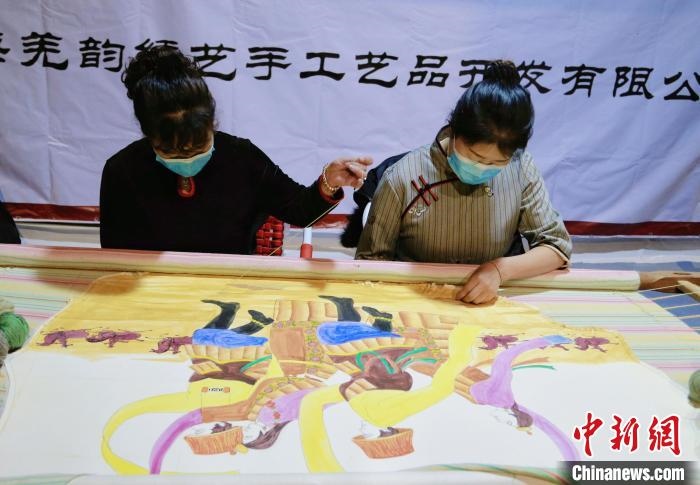 圖為皮繡藝人在市集上“秀”指尖技藝?！●R銘言 攝